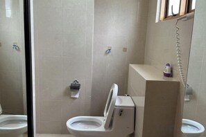 A bathroom with two toilets, a shower, and a toilet paper holder. - Sunway Resort Suites @ Sunway Lagoon by Landmark (Subang Jaya)