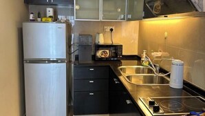 A compact kitchen with a refrigerator, microwave, toaster, and a sink. - Sunway Resort Suites @ Sunway Lagoon by Landmark (Subang Jaya)