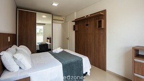 A modern bedroom with a bed, a wooden wardrobe, and a mirror. - Apt. w/ Balcony and BBQ 250m From the sea Mrs0402 (Bombinhas)