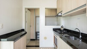A modern kitchen with black countertops, wooden cabinets, and a stainless steel sink. - Apt. w/ Balcony and BBQ 250m From the sea Mrs0402 (Bombinhas)