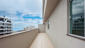 A narrow balcony with a tiled floor, a view of the sea, and adjacent buildings. - Apt. w/ Balcony and BBQ 250m From the sea Mrs0402 (Bombinhas)