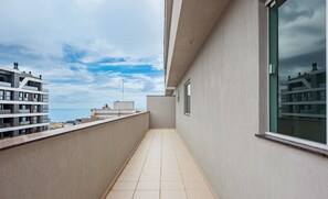 A narrow balcony with a tiled floor, a view of the sea, and adjacent buildings. - Apt. w/ Balcony and BBQ 250m From the sea Mrs0402 (Bombinhas)
