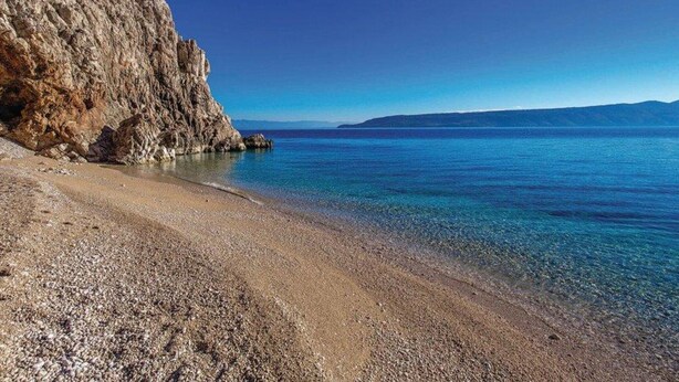 A rocky coastline with clear blue waters and a distant view of a mountain range. - Holiday Home Brsec-Two Bedroom Holiday Home with Sea View (Brsec)