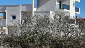 A modern two-story building with a flat roof, large windows, and a balcony. - Apartments Matković - Two Bedroom Apartment1 (Vir)