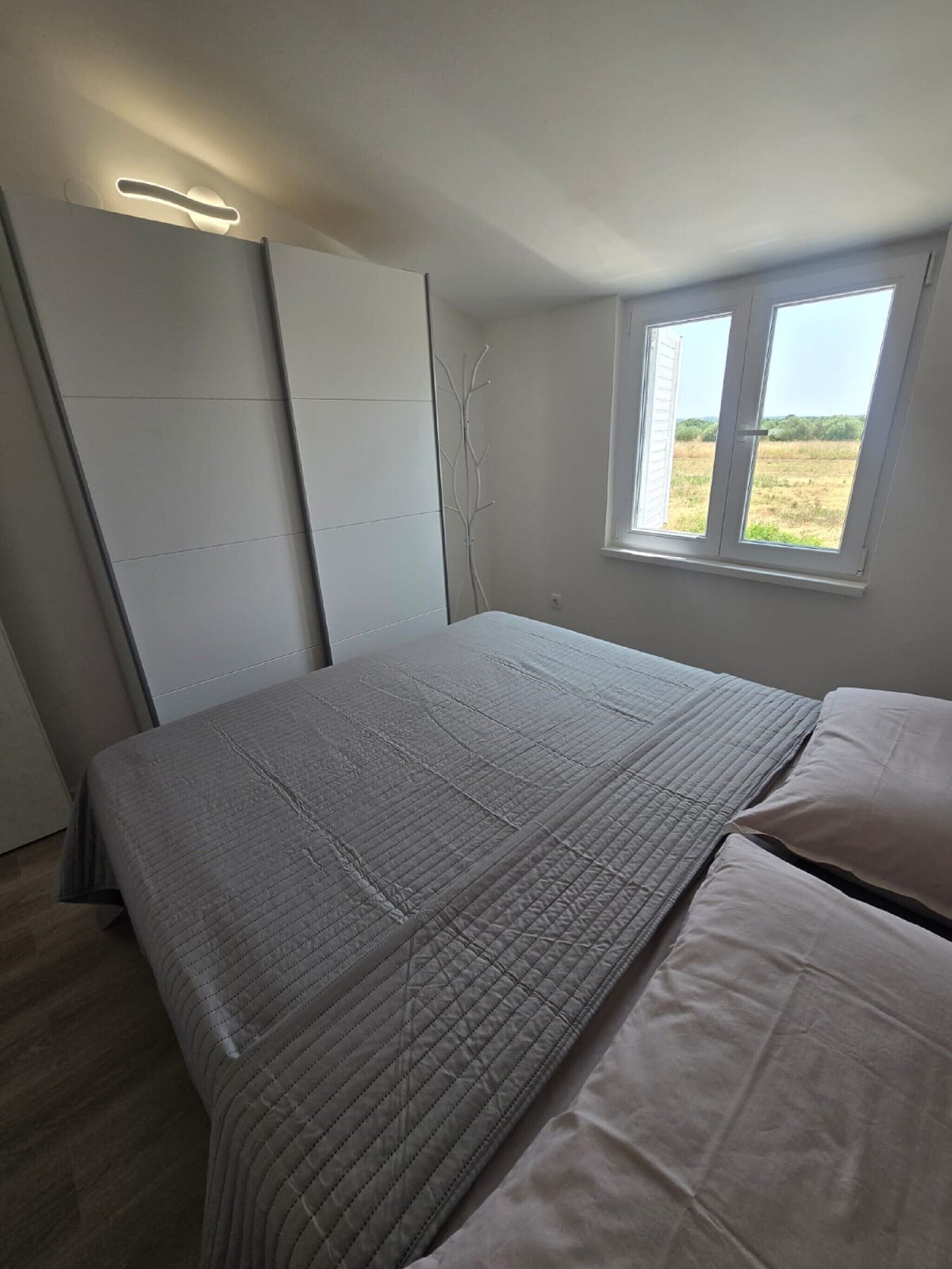 Une chambre à coucher avec un lit, une fenêtre et une armoire.