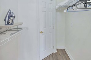 A laundry area with an iron, a drying rack, and a door. - Updated Large 2BR in Azalea Lakes, Pools, PondView (Myrtle Beach)
