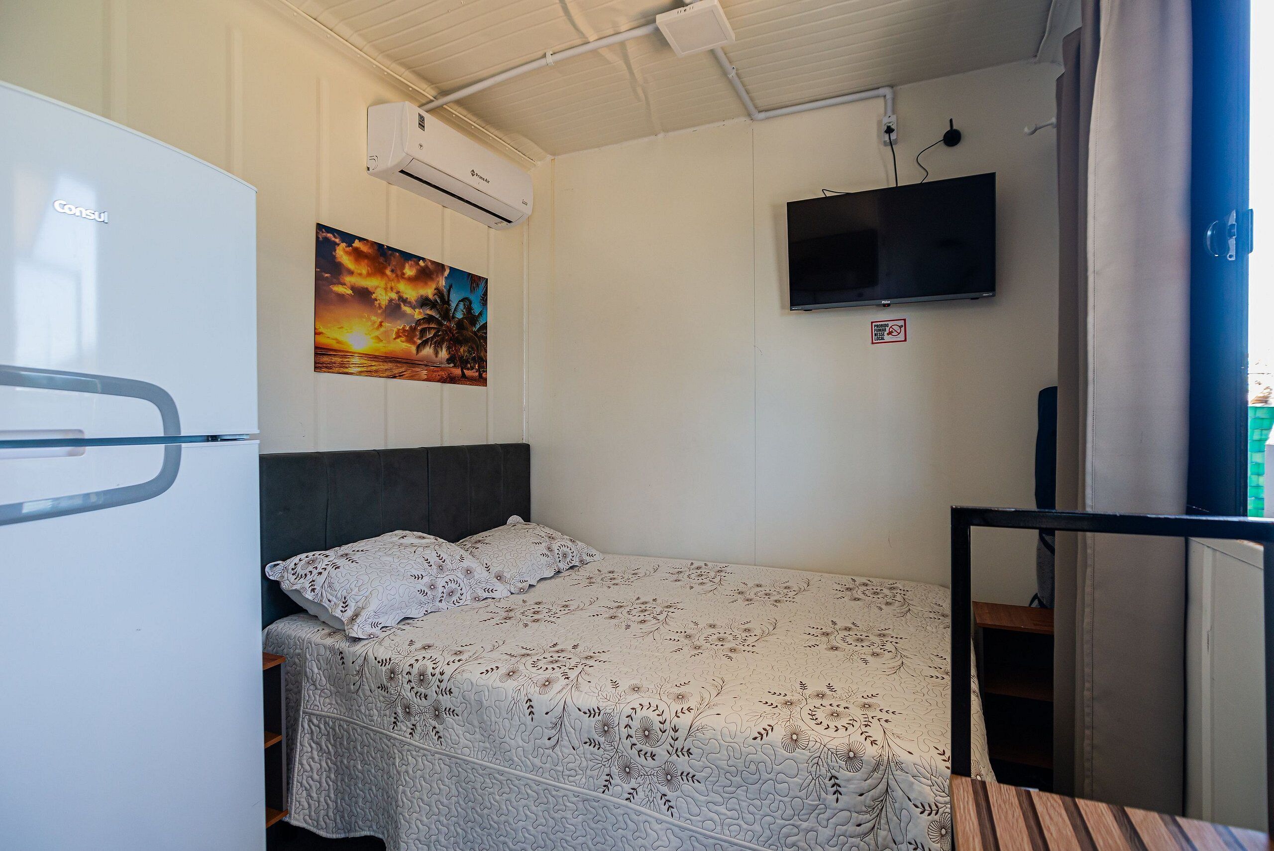 Un dormitorio con cama, armario, televisor de pantalla plana y aire acondicionado.