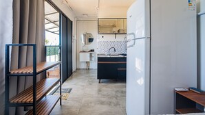 A compact kitchen with a refrigerator, sink, and a small countertop. - Container Beira Mar Solar Analuz (Navegantes)