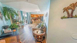 A spacious living area with a kitchen, dining area, and a large plant. - Spacious City View - Close to Boardwalk, Location! (Myrtle Beach)