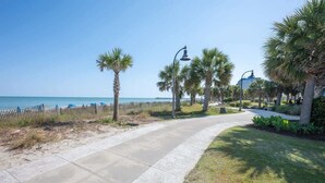 A paved walkway with palm trees and a view of the ocean. - Spacious City View - Close to Boardwalk, Location! (Myrtle Beach)