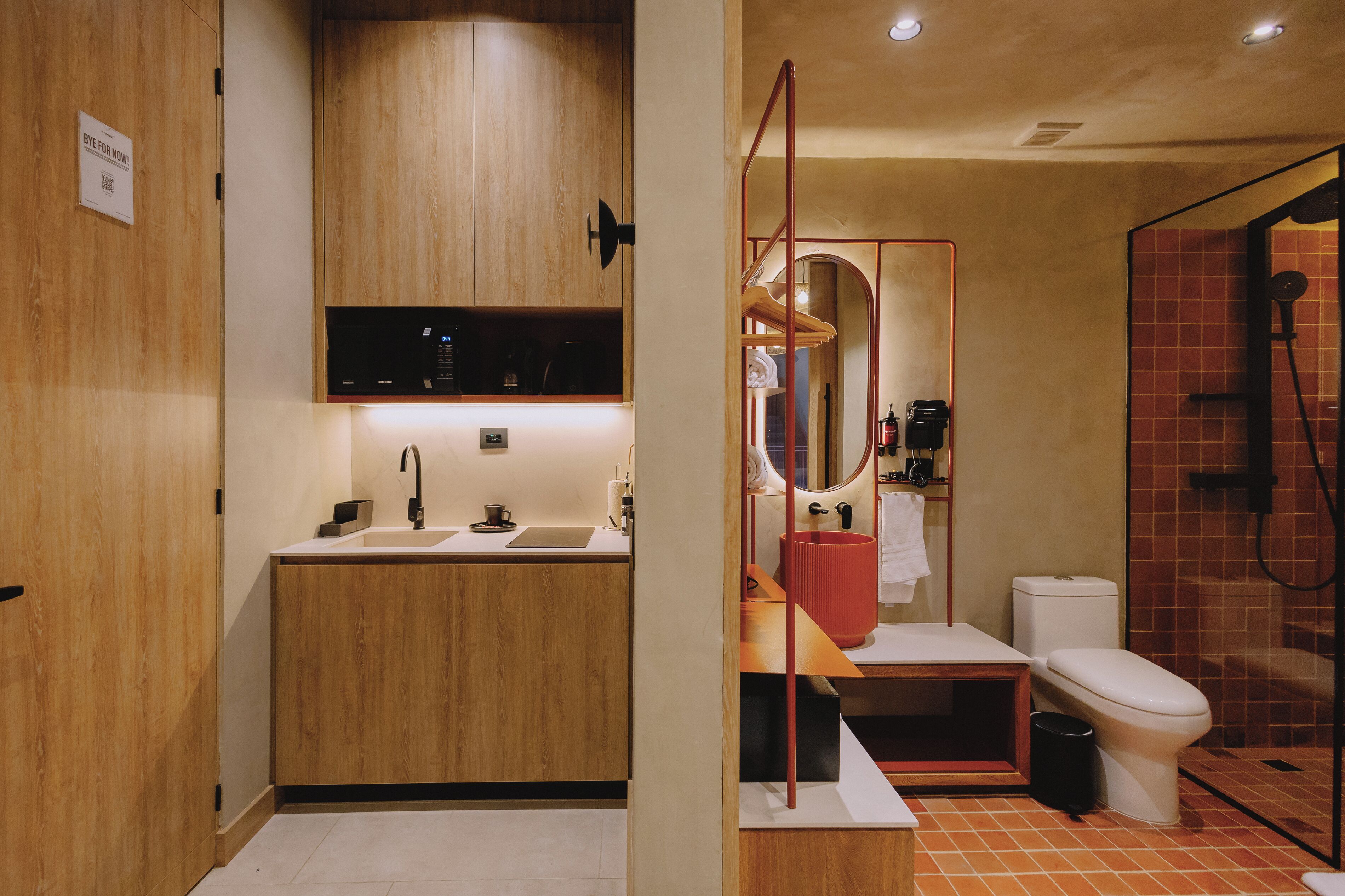 Un bagno moderno con un mobile vanitario in legno, un lavabo, uno specchio, un water e uno spazio doccia.