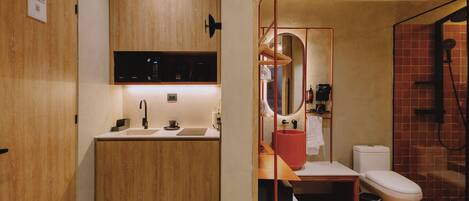Un bagno moderno con un mobile vanitario in legno, un lavabo, uno specchio, un water e uno spazio doccia.