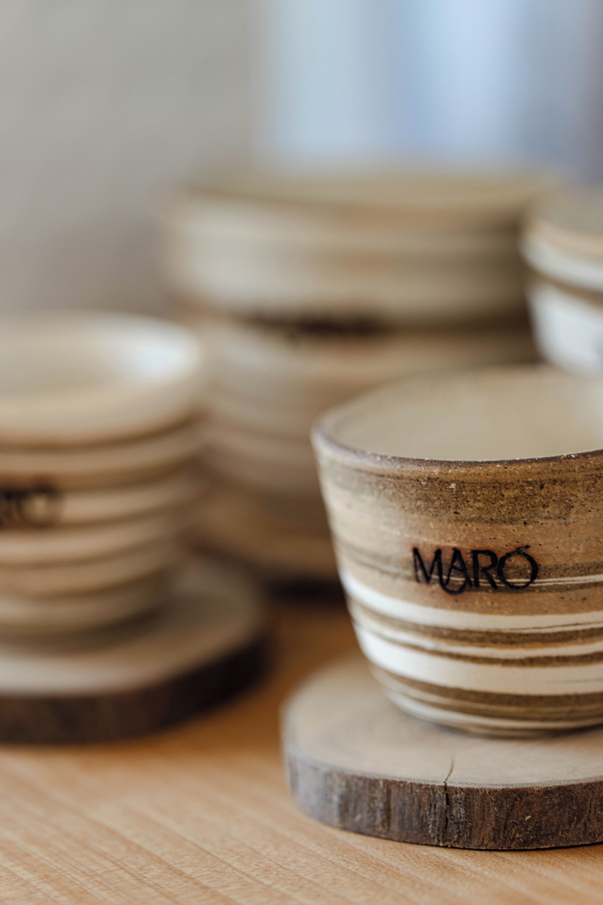 A stack of wooden coasters with the word "MARO" engraved on one.