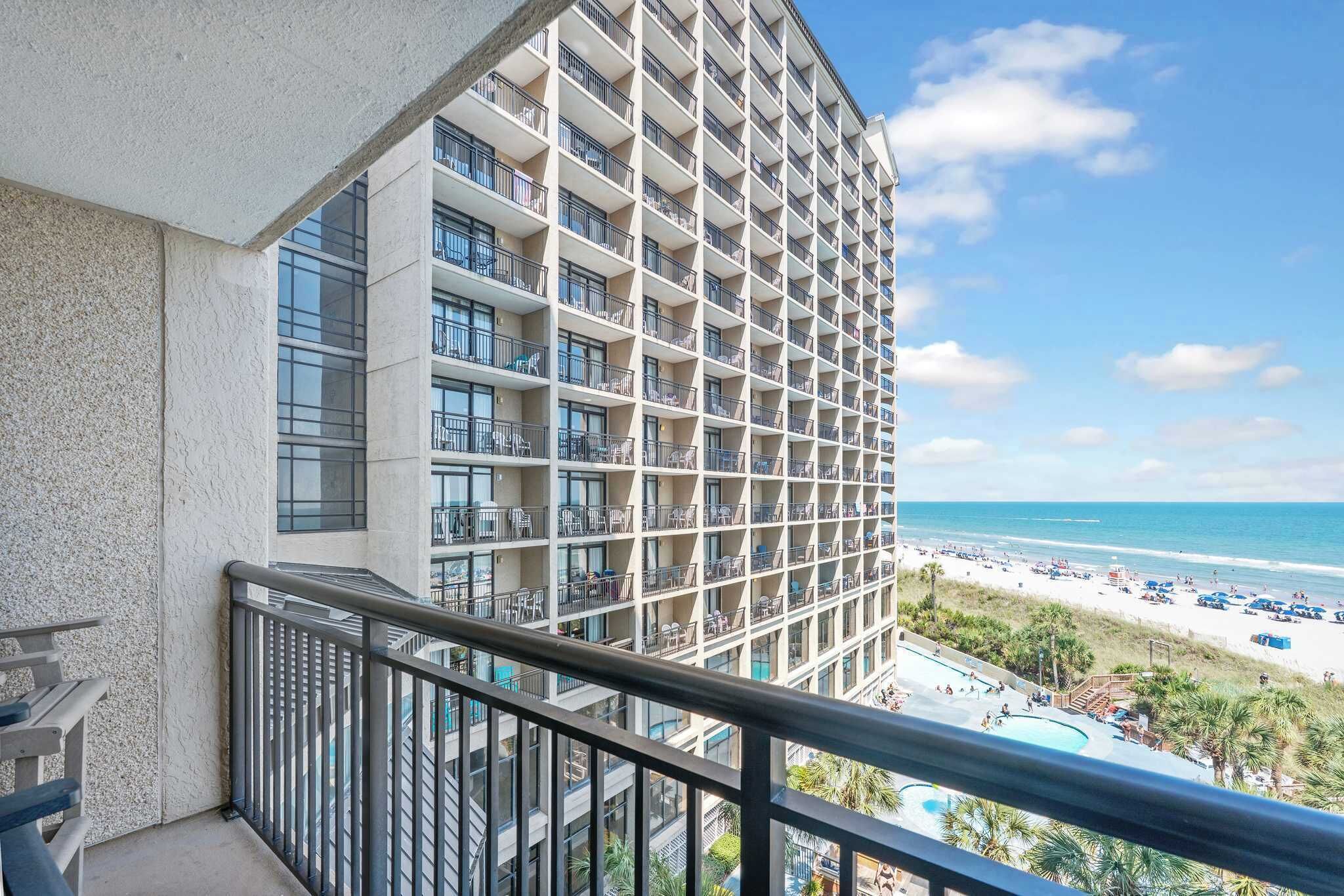 Ein Hochhaus-Hotel mit mehreren Balkonen mit Blick auf einen Strand.
