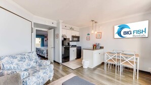 A modern apartment with a living room, kitchenette, and dining area. - Remodeled 1BR at Caravelle ,Oceanview Suite, Pools (Myrtle Beach)