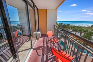 Un balcon avec vue sur la plage et l’océan.