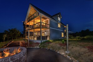 A two-story house with a stone fire pit in the foreground. - Fireside Lodge | Lake View, Hot Tub, & Game Room! (Sevierville)