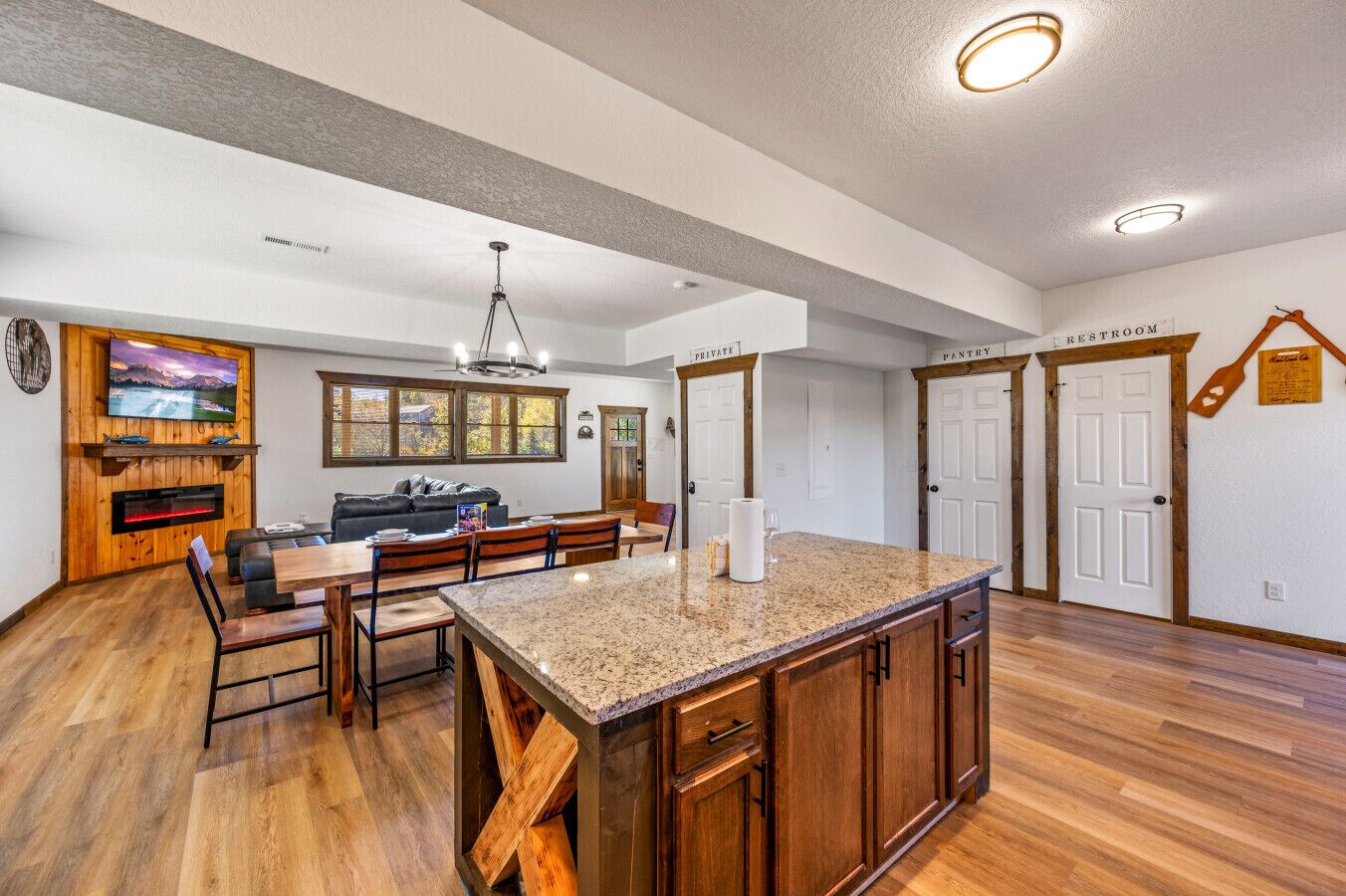 A spacious kitchen with a large island, wooden cabinets, and a dining area with a sofa and chairs.