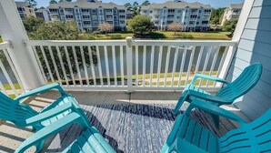 A balcony with turquoise chairs and a view of apartment buildings. - Large 3BR Private Condo - Magnolia Pointe - Pools (Myrtle Beach)