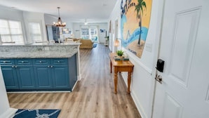 A spacious kitchen with a large island, blue cabinets, and a wooden floor. - Large 3BR Private Condo - Magnolia Pointe - Pools (Myrtle Beach)