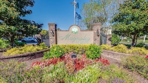 A sign with "Magnolia Pointe" written on it, surrounded by a landscaped garden with various plants and flowers. - Large 3BR Private Condo - Magnolia Pointe - Pools (Myrtle Beach)