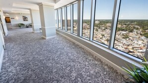 Ein Hotelgang mit großen Fenstern und Blick auf die Stadt.