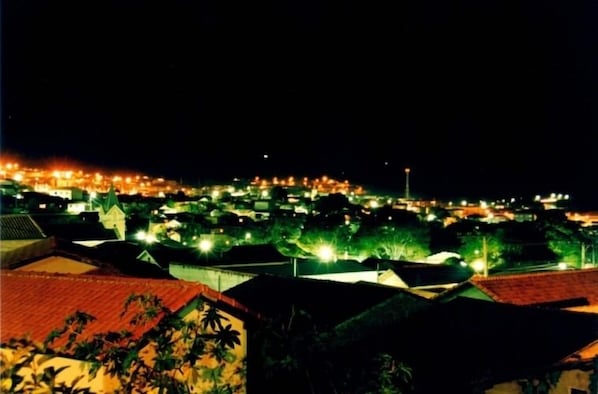 A nighttime view of a densely populated town with illuminated buildings and streetlights.