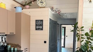 A modern kitchen with wooden cabinets, a black countertop, and a clock on the wall. - "MOUTY": A DELIGHTFUL WOODEN CHALET AT THE EDGE OF THE FOREST (Le Chambon-sur-Lignon)