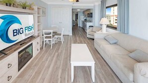 Ett modernt vardagsrum med en soffa, ett soffbord och en tv-skärm som visar logotypen för företaget ”BIG FISH Rentals”.