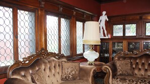 Ein Zimmer mit zwei verzierten Sofas, einer Lampe und einer Statue.