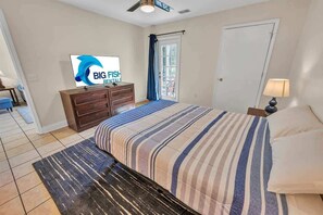 A bedroom with a bed, a TV, a dresser, and a door. - NEW Large 2BR- Pools - River Oaks Golf - Hot Tubs (Myrtle Beach)