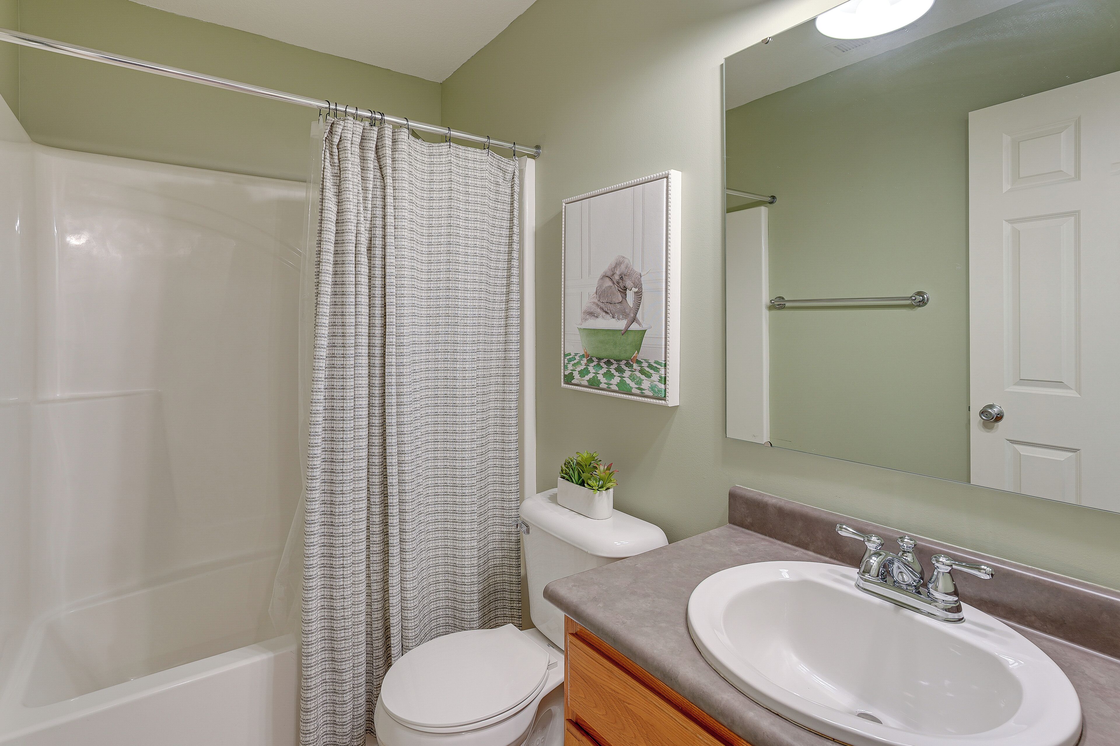 A bathroom with a bathtub, toilet, and sink.