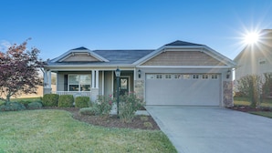 A two-story house with a front porch, a garage, and a well-maintained lawn. - Private Yard + Pond Views: Fort Wayne Family Home! (Fort Wayne)