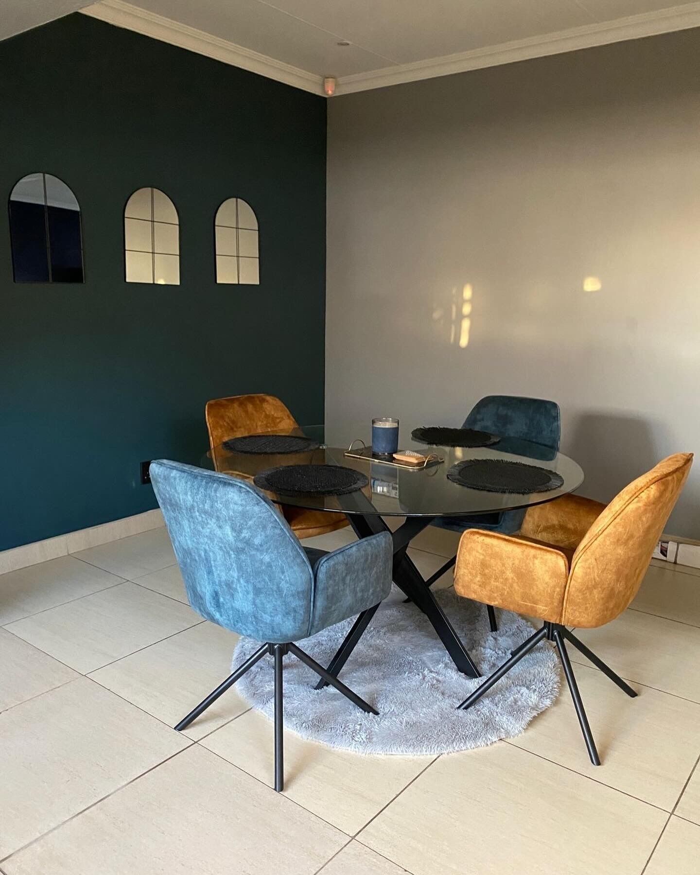 Un coin repas avec une table ronde, quatre chaises et un tapis moelleux.