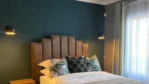 Un dormitorio moderno con una cama grande, una mesita de noche y una lámpara en el techo.