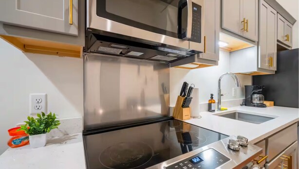 A modern kitchen with stainless steel appliances, a built-in oven, a microwave, and a sink with a faucet. - Near Hospitals & DT  ~  Vibey+Parking+W/D+Churchill (Louisville)