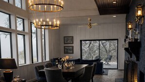 A spacious room with a dining area, seating, a fireplace, and large windows. - Private and Unique 14 acre European Lakefront Villa in Texas! (Hubbard)