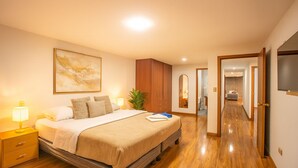 A hotel room with a bed, bedside table, lamp, and a large mirror. - Gran Esmeralda Space View and Style (Cuenca)