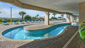 Ein Poolbereich mit Liegestühlen und einem gefliesten Pool.