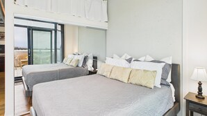 A bedroom with two beds, a nightstand, and a window with blinds. - Your Private Downtown Oasis (Victoria South)
