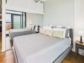 A bedroom with two beds, a nightstand, and a window with blinds. - Your Private Downtown Oasis (Victoria South)