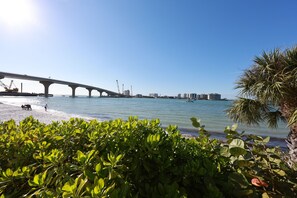 A coastal view with a bridge, clear sky, and lush greenery. - Cozy beach condo on desirable Fort Myers Beach - Unit 1107 (Fort Myers Beach)