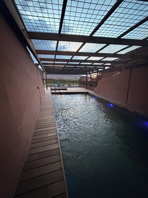 An indoor swimming pool with a wooden deck and a glass ceiling. - Honey Rock Landing (Delta)