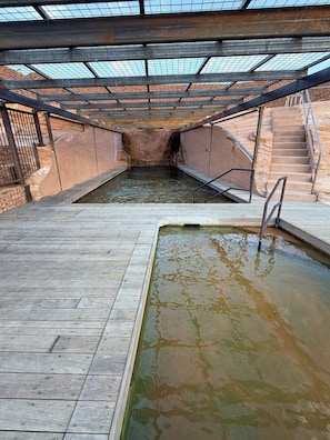 A swimming pool with a wooden deck and a covered area with a metal roof. - Honey Rock Landing (Delta)