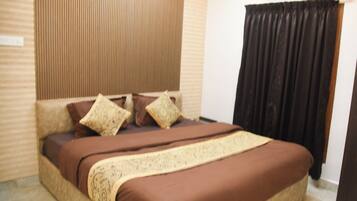 A bedroom with a bed, a wardrobe, a window with curtains, and an air conditioning unit.
