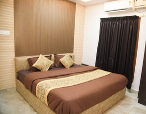 A bedroom with a bed, a wardrobe, a window with curtains, and an air conditioning unit. - Pearl Paradise (Tirupporur)