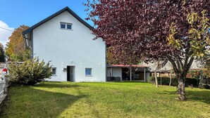 A modern two-story house with a flat roof, a small front porch, and a well-maintained lawn. - Stunning home in Salopeki Modruski with WiFi (Salopeki Modruski)