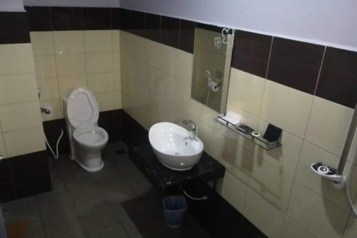 A small bathroom with a toilet, sink, and mirror.