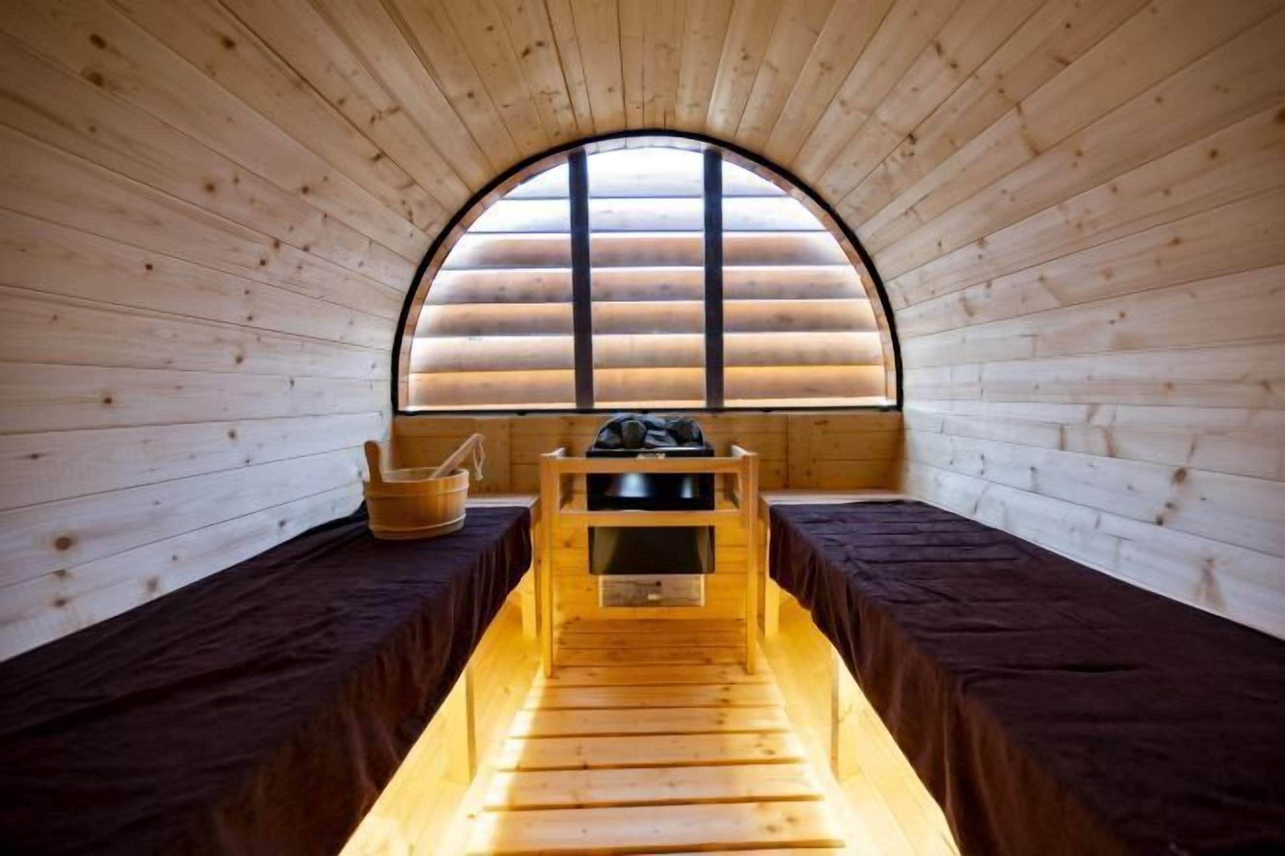 A wooden interior with a bench, a window, and a table.