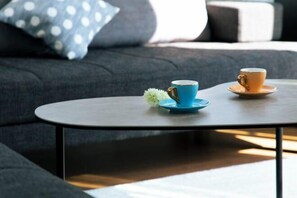 A modern living room with a round coffee table, two cups, and a small decorative plant. - Inn the Fuji (Fujiyoshida)